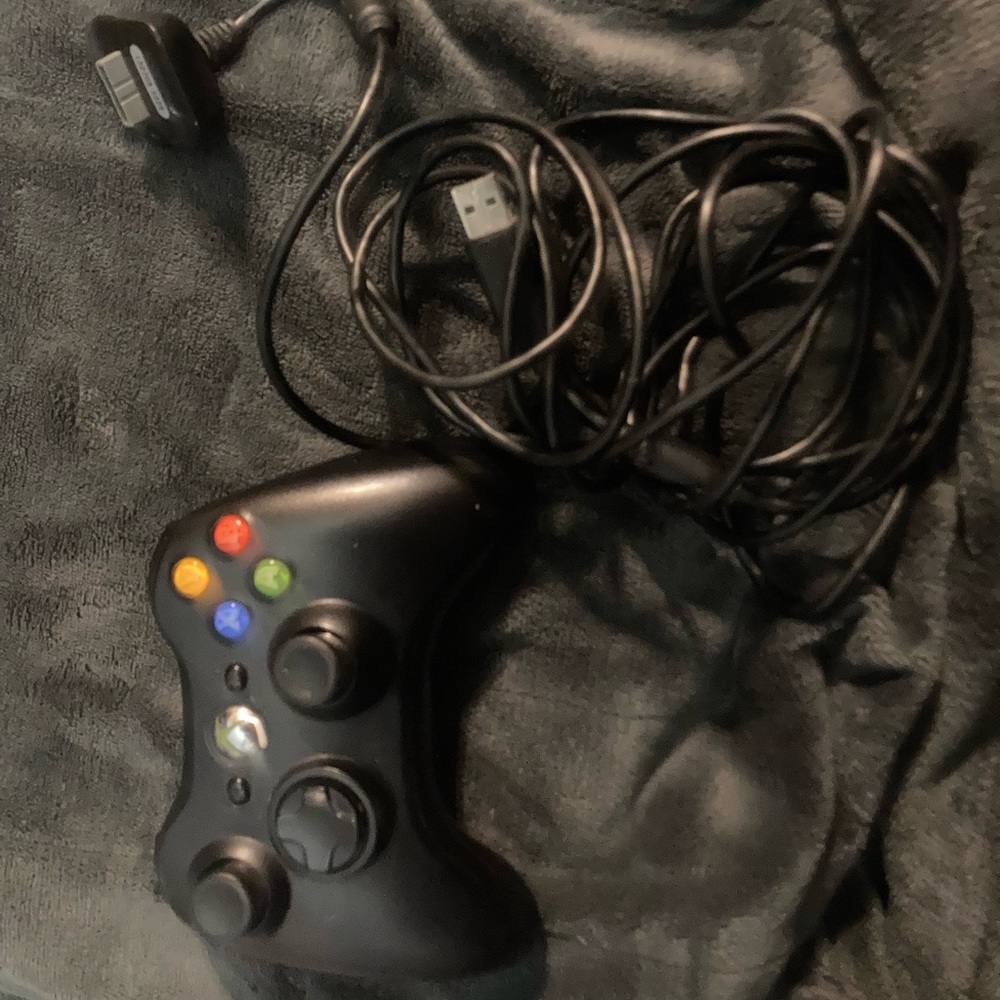 Black Xbox 360 controller,  with the charger